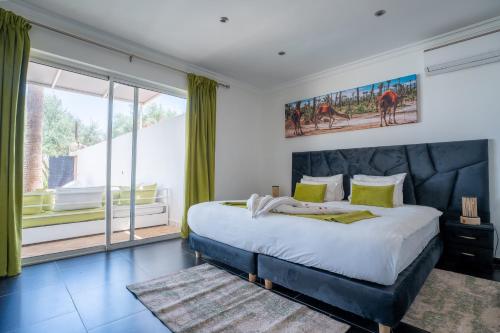 a bedroom with a large bed and a large window at DOMAINE DU DOUAR in Marrakech
