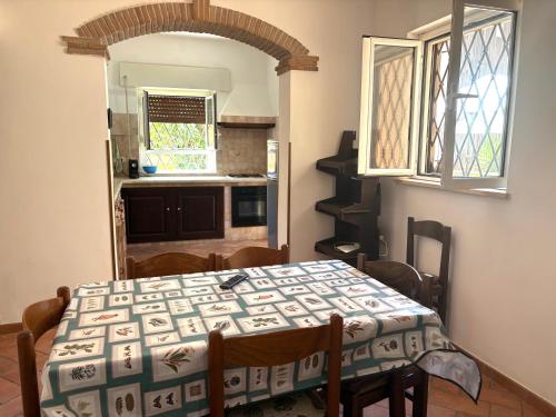 a dining room with a table and a kitchen at Vacanze Romane in Morlupo