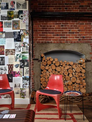 two red chairs in front of a brick fireplace at The Bow Hotel in Portsmouth