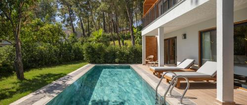a swimming pool in the backyard of a house at Mövenpick Resort Antalya Tekirova - Ultra All Inclusive in Tekirova