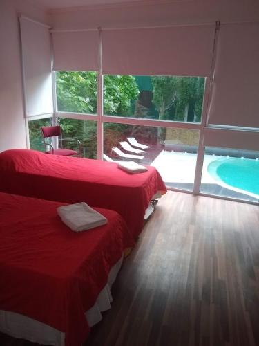 a bedroom with two beds and a large window at EL GAVION a 150 m de playa in Mar Azul