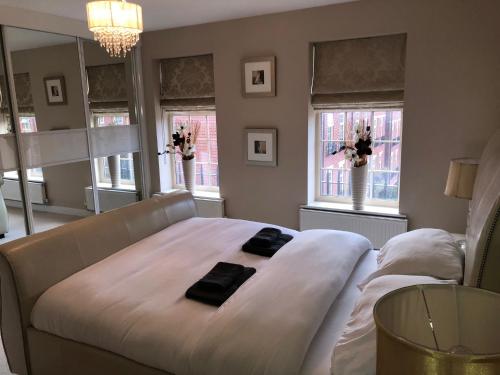 a large white bed in a room with windows at 2-Bed Hillside House - Sleeps 4 Garden & Parking in Sheffield