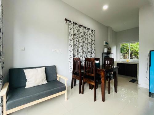 a living room with a couch and a table and chairs at บ้าน2ห้องนอนเงียบสงบ15นาทีถึงชายหาด in Ban Khlong Haeng