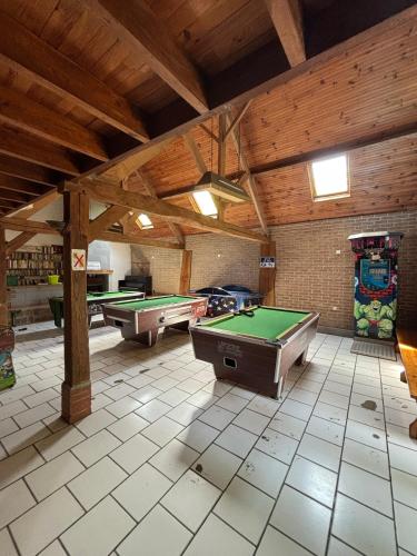 une grande chambre avec des billards dans un bâtiment dans l'établissement Camping La Tentation, à Renty