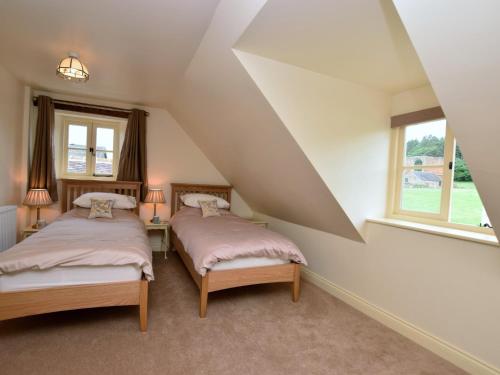 two beds in a attic room with two windows at 2 Bed in Newthorpe 47032 in Greasley