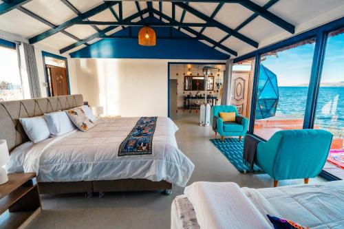 a bedroom on a boat with a bed and chairs at Uros Titicaca Lodge in Puno