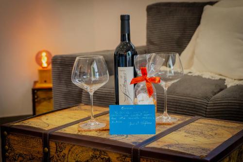 une bouteille de vin et deux verres à vin sur une table dans l'établissement 36 2 L'air marin Penthouse climatisé Netflix Stationnement gratuit Accès direct Autoroutes et plages, à Narbonne