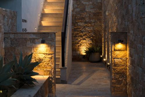 a staircase in a building with lights on the wall at Pnoes Luxury Suites in Paliouri