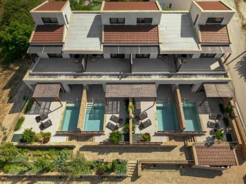an aerial view of a resort building with swimming pools at Pnoes Luxury Suites in Paliouri