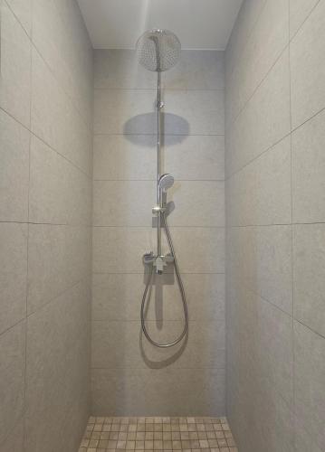 a shower with a shower head in a bathroom at Maison Parenthèse Prestige Tours Centre in Tours