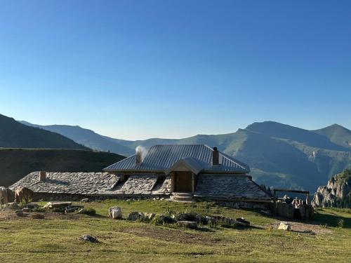 a building on a hill with mountains in the background at Guest house Stanet 1Maj in Tetovo