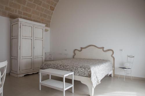 a bedroom with a bed and a cabinet and a table at grottedisileno in Castellaneta