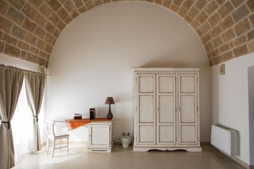 an archway in a room with a white cabinet and a table at grottedisileno in Castellaneta