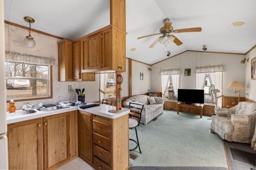 a kitchen with wooden cabinets and a living room at Casa Villa Park 91 in Russell