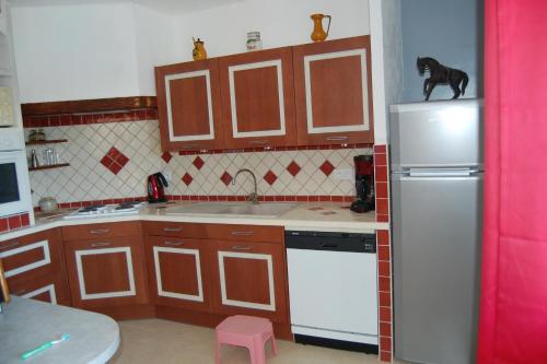 a kitchen with a dog on top of the refrigerator at Maison de vacances avec piscine Var in Callas
