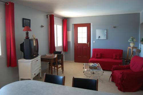 a living room with a red couch and a tv at Maison de vacances avec piscine Var in Callas