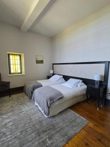 a large bedroom with two beds and a table at Château de Courtebotte in Saint-Jean-de-Blaignac