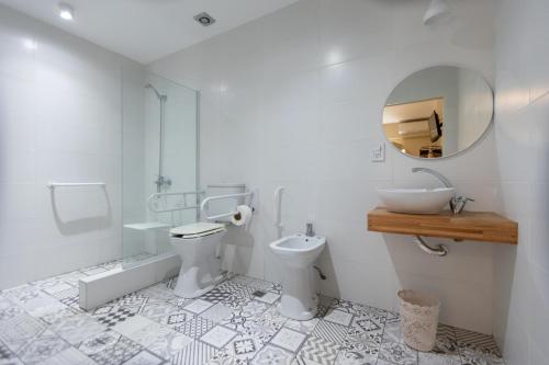 a bathroom with a toilet and a sink and a mirror at Posada de las Aguilas Hotel Boutique in Ezeiza
