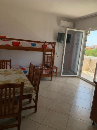 a room with a table and a dining room with bunk beds at Hotel Armela in Velipojë