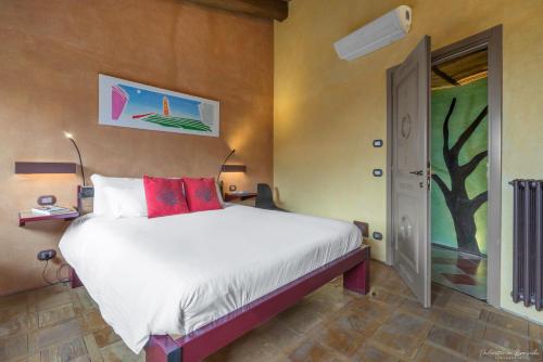 a bedroom with a bed and a painting on the wall at Palazzo d'Assi - Guest house in Monforte dʼAlba