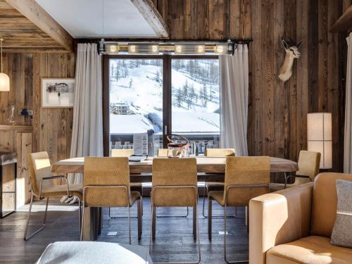 une salle à manger avec une table et des chaises et une fenêtre dans l'établissement Prestigieux duplex 4 chambres avec hammam et cheminée, proche des pistes à Val-d'Isère - FR-1-567-98, à Val dʼIsère