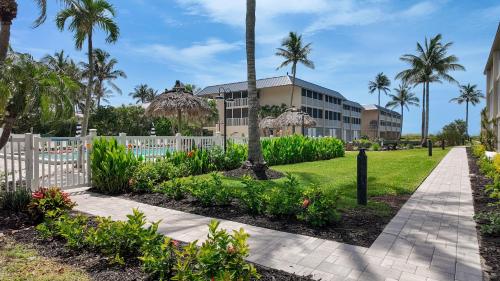 a walkway in front of a building with palm trees at Sanibel Siesta on the Beach in Sanibel