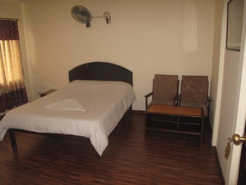 a small bedroom with a bed and a chair at Kathmandu Madhuban Guest House in Kathmandu
