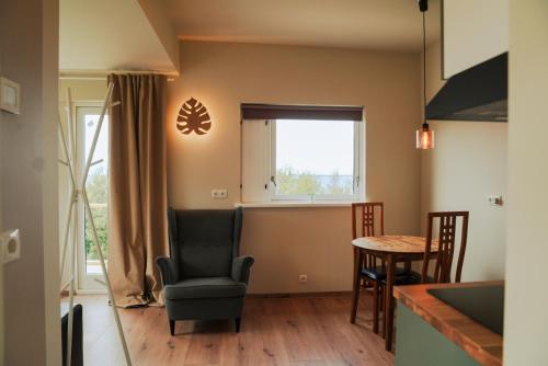 Una sala de estar con una silla y una mesa. en Hotel Hafnarfjall, en Borgarnes