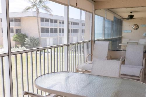 a balcony with a glass table and chairs on it at Sanibel Siesta on the Beach in Sanibel