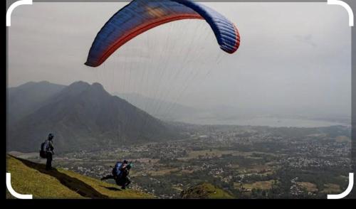 two people standing on a hill with a parachute at Al Mubeen home stay in Nishāt