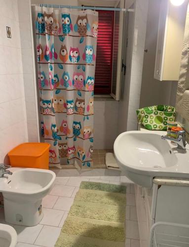 a bathroom with a sink and a shower curtain at Nonna Maria B&B Home restaurant in La Marinella