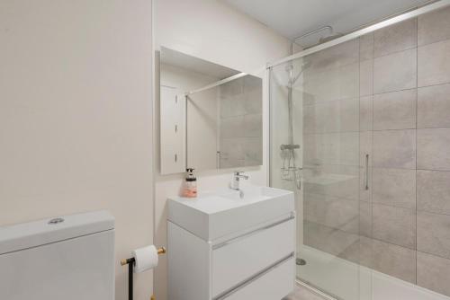 a white bathroom with a sink and a shower at Luxury 3 BR Apartment with Terrace, pool & gym in Mijas Costa