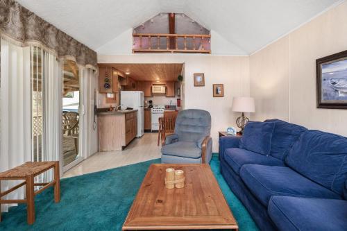 a living room with a blue couch and a table at Vacation Home Rental PM C-06 in Russell