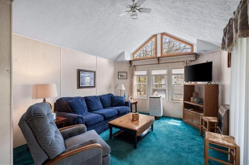 a living room with a blue couch and a tv at Vacation Home Rental PM C-06 in Russell