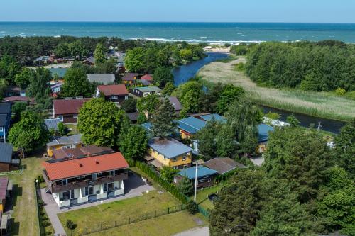an aerial view of a town with houses and a river at Apartamentai Trys pušys in Šventoji