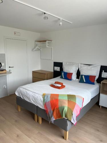 a bedroom with a bed with a rainbow blanket on it at Business Accommodation 'Urban Living' Intimate in Geel
