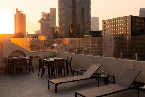 a rooftop patio with tables and chairs and a city skyline at Eurostars Zona Rosa Suites in Mexico City