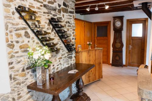 a room with a stone wall with wine bottles at BnB Feuille de Vigne in Saint-Léonard