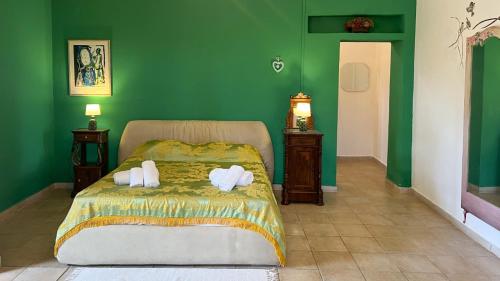a green bedroom with a bed with towels on it at Masseria Brica Rossa in Thurio