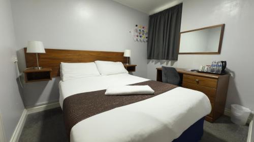 a hotel room with a large bed and a desk at The Terrace Lodge Hotel in Yeovil