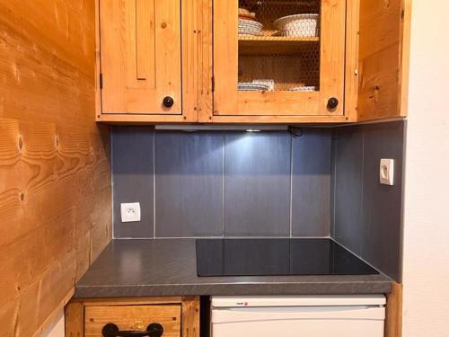 une cuisine avec des armoires en bois et un comptoir noir dans l'établissement Superbe T2 pour 4 personnes, centre Avoriaz, ski aux pieds, balcon sud, Wifi - FR-1-314-190, à Morzine