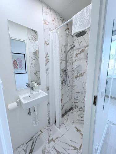 a white bathroom with a sink and a mirror at Endla Hostel ja Apartamendid in Haapsalu