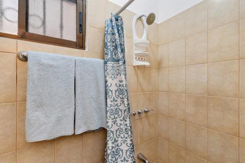 Un baño con ducha con toallas y ventana. en 2-bd Condo With Pool, Walk To Beach, en Coco