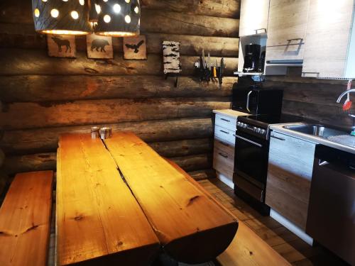 a kitchen with a wooden table in the middle of it at Kelo Villa for 8, with hot tub, by lake Päijänne in Jyväskylä