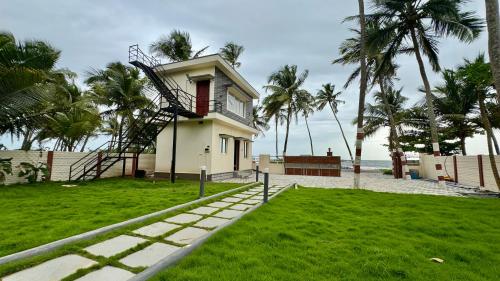 a house with a staircase leading up to the beach at CasaNada Beach Stay in Udupi