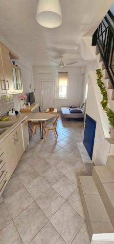 a kitchen and living room with a staircase and a table at Nicholas House in Siviri