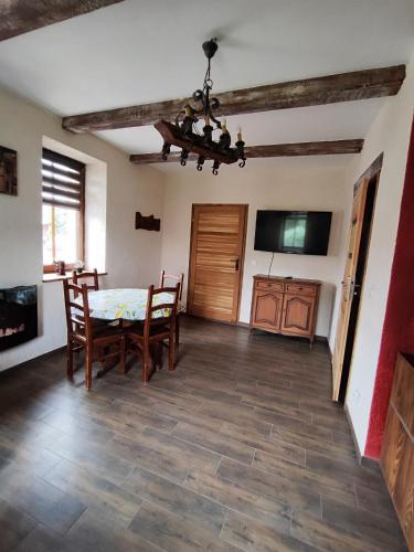 a dining room with a table and chairs and a television at Gościniec Villa Romana in Skorka
