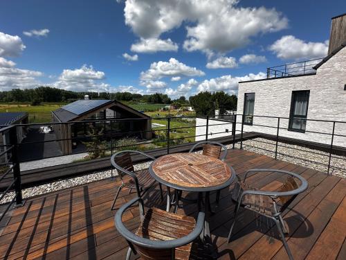 a patio with a table and chairs on a deck at Vakantiewoning Erf64 in Sint-Amands