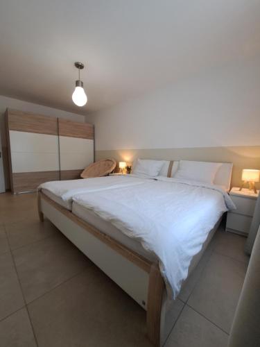 a bedroom with a large bed with white sheets at Kernsaniert Barrierefrei in Vlotho
