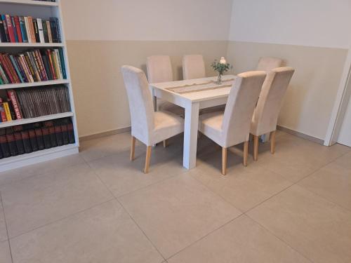 a dining room table with chairs and a book shelf at Kernsaniert Barrierefrei in Vlotho